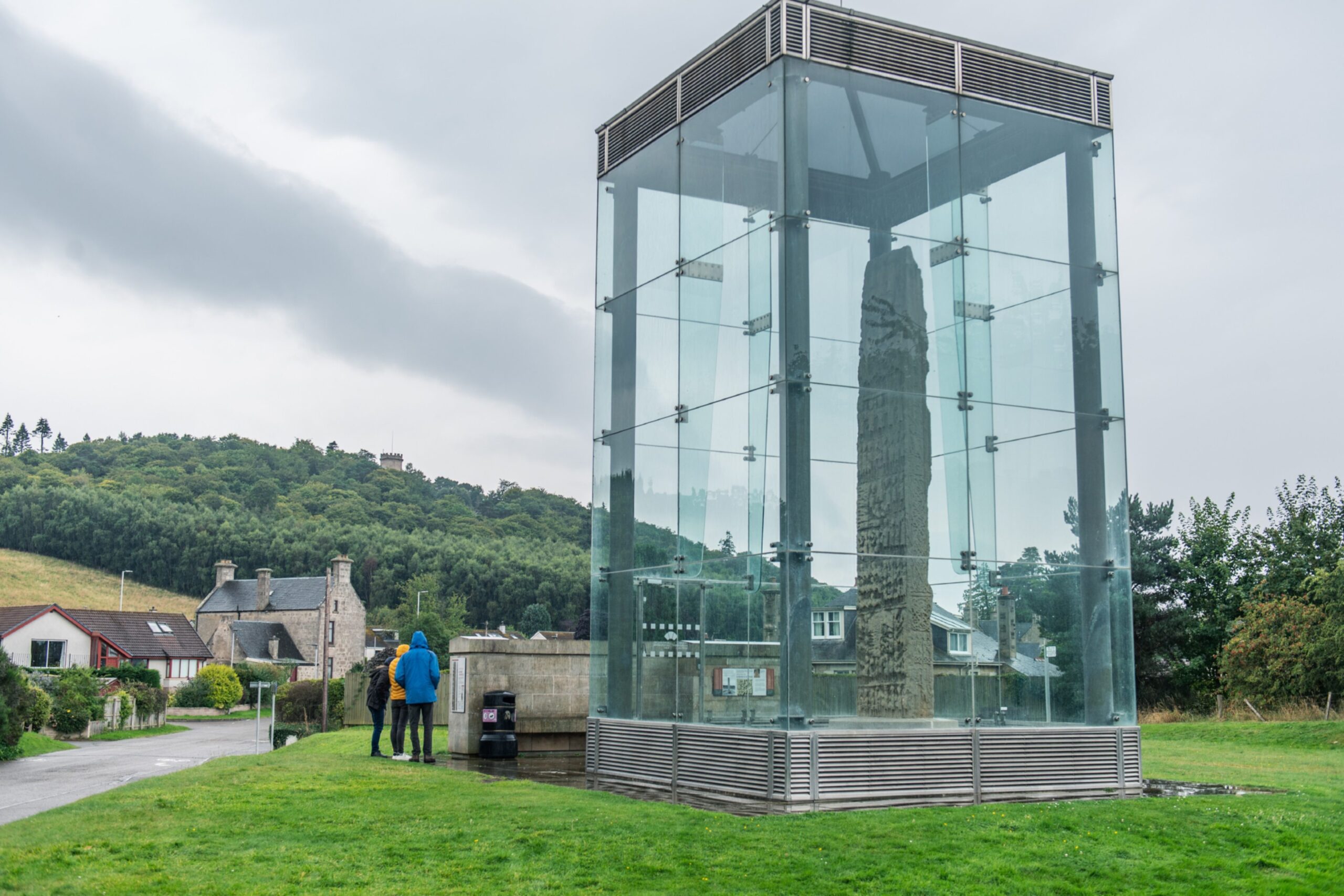 Sueno's Stone in Forres with tourists visiting. 