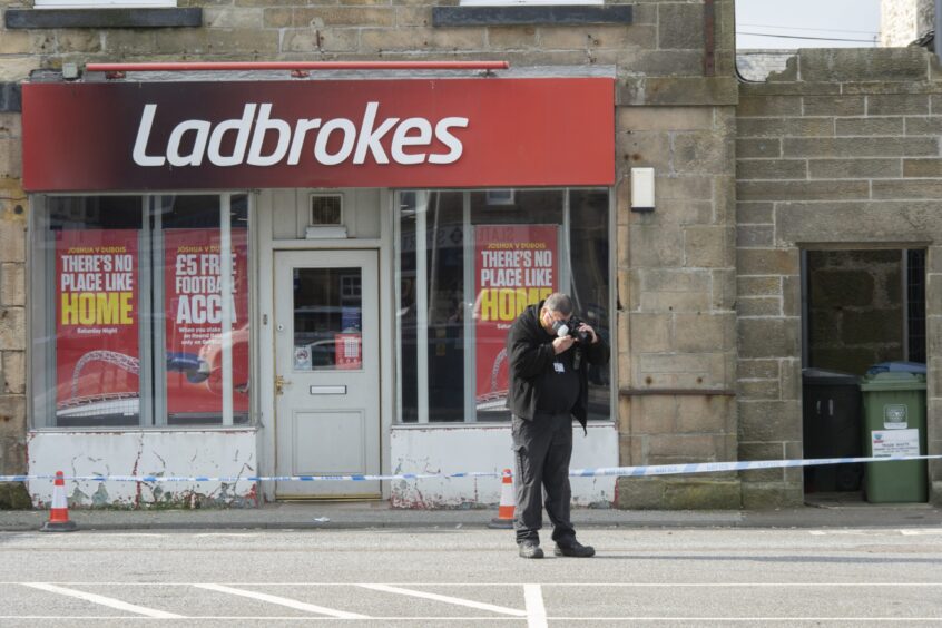 Man taking photo at scene of incident in Cluny Square in Buckie 