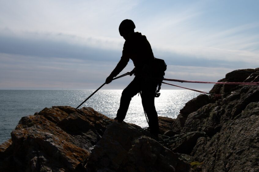 A silhouette of a female climber