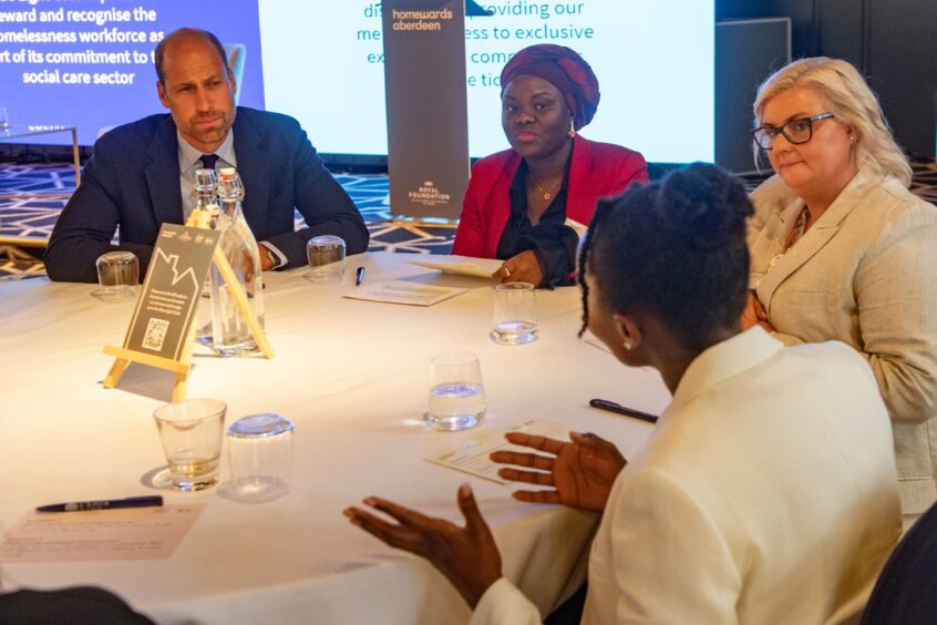 Prince William sitting next to Anu Kasim from Homewards Aberdeen