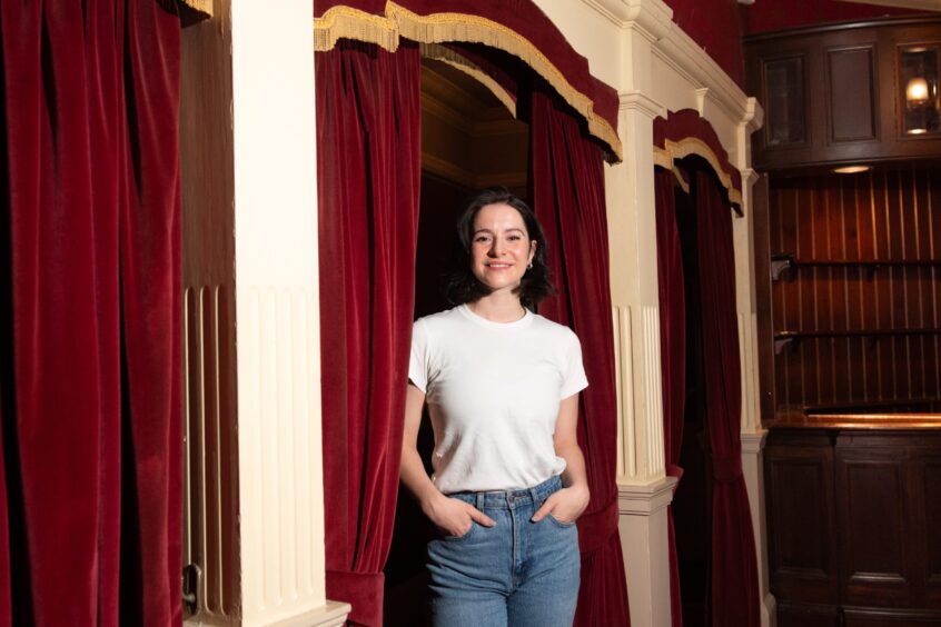 Jenna Innes standing next to red curtain