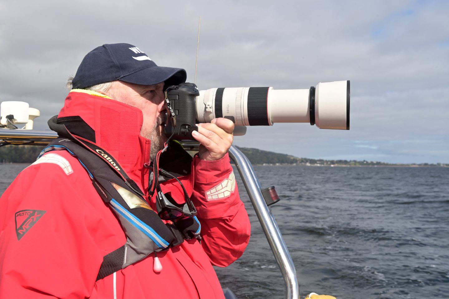 Charlie Phillips taking photos on the boat with Dolphin Spirit.