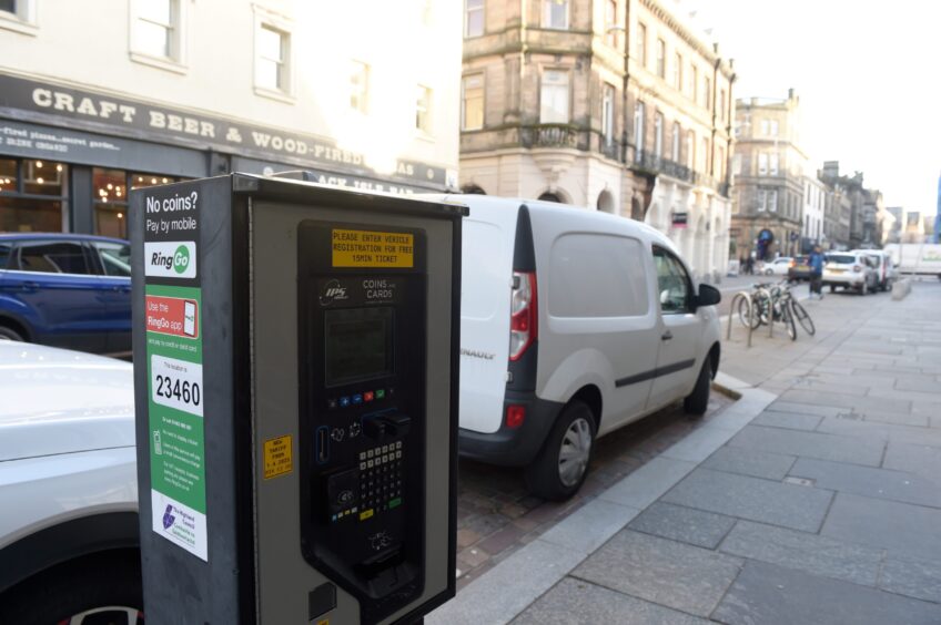 Parking metre beside parked cars on Church Street, Inverness.