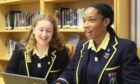 sitting in front of a laptop, rachel and yoma smile as they talk about being in an all girls school in Aberdeen