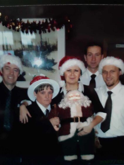 Irene Parker and work colleagues in Christmas hats. 