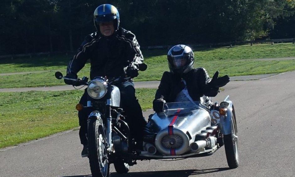 Jason Dorey, chairman of the Grampian Transport Museum driving a motorcycle with 80-year-old Irene Davidson in a sidecar.