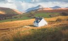 Lone traditional Scottish Highlands white croft house