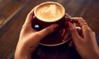 woman's hands holding a latte