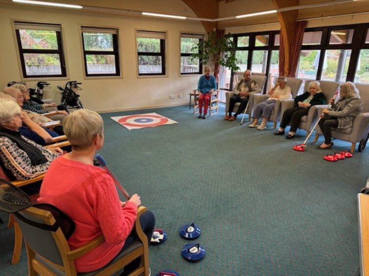 Sheltered housing residents playing floor curling 