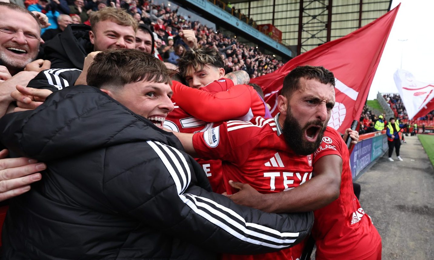 Aberdeen's Graeme Shinnie and Leighton Clarkson celebrate with fans after Ante Palaversa scores to make it 3-2 against Hearts at Pittodrie. Image: SNS