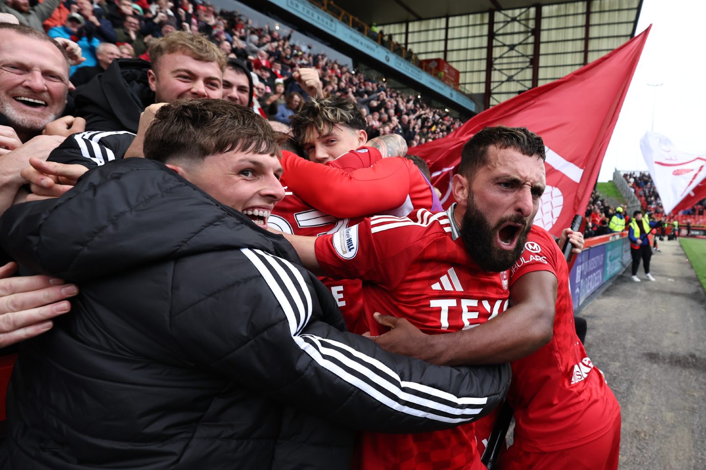 Aberdeen's Graeme Shinnie and Leighton Clarkson celebrate with fans after Ante Palaversa scores to make it 3-2 against Hearts at Pittodrie. Image: SNS 