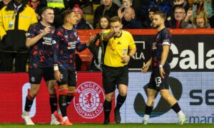 Referee John Beaton gives a penalty to Aberdeen for a handball against John Souttar after a VAR review. Image: SNS.