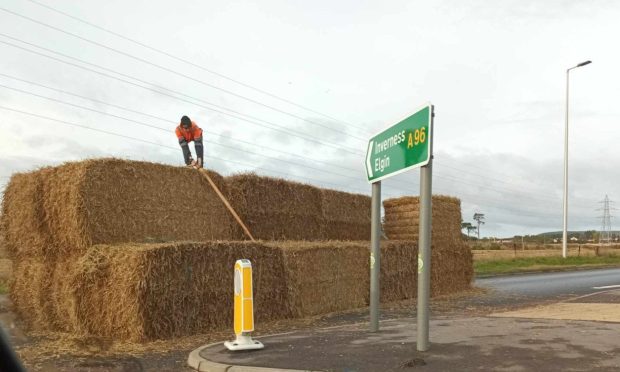 Man tries to strap down hay bales on A96