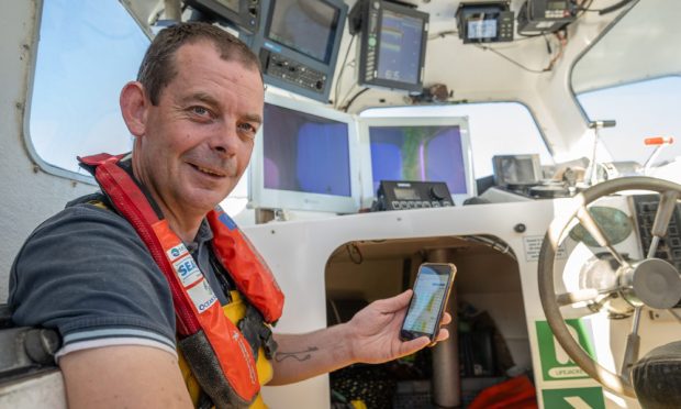 Iain MacAskill at sea with his mobile phone