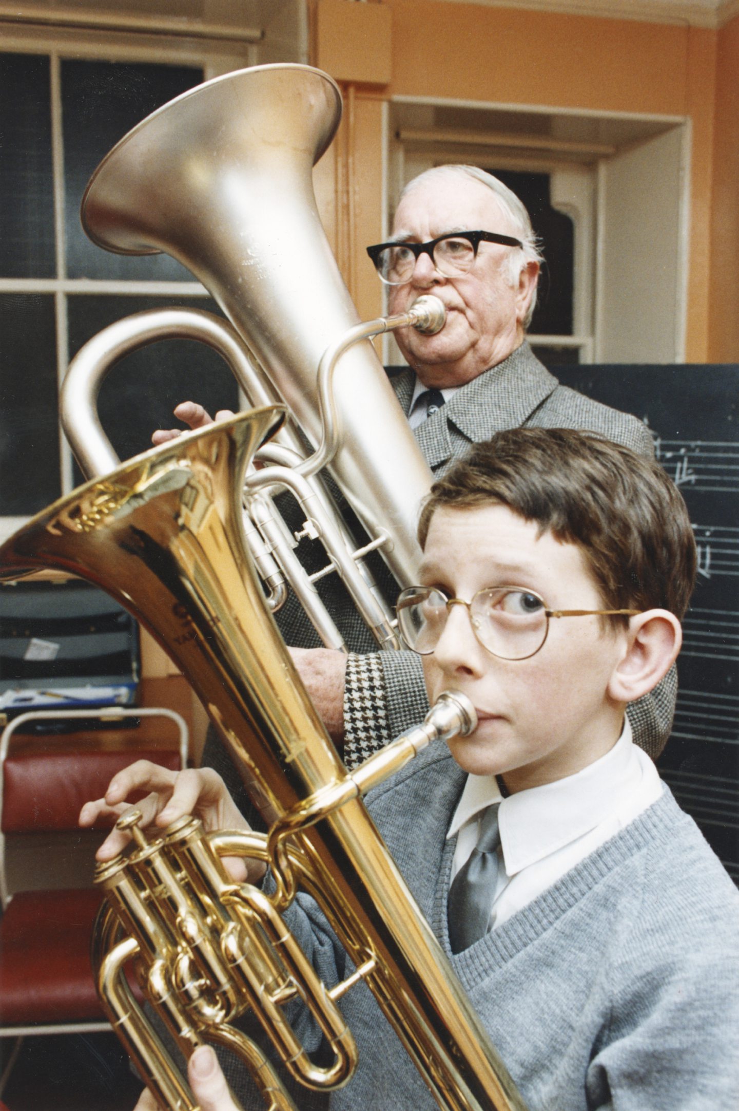 A boy plays a tenor horn while a man plays a tuba in the Boys' Brigade silver band in Aberdeen in 1991.