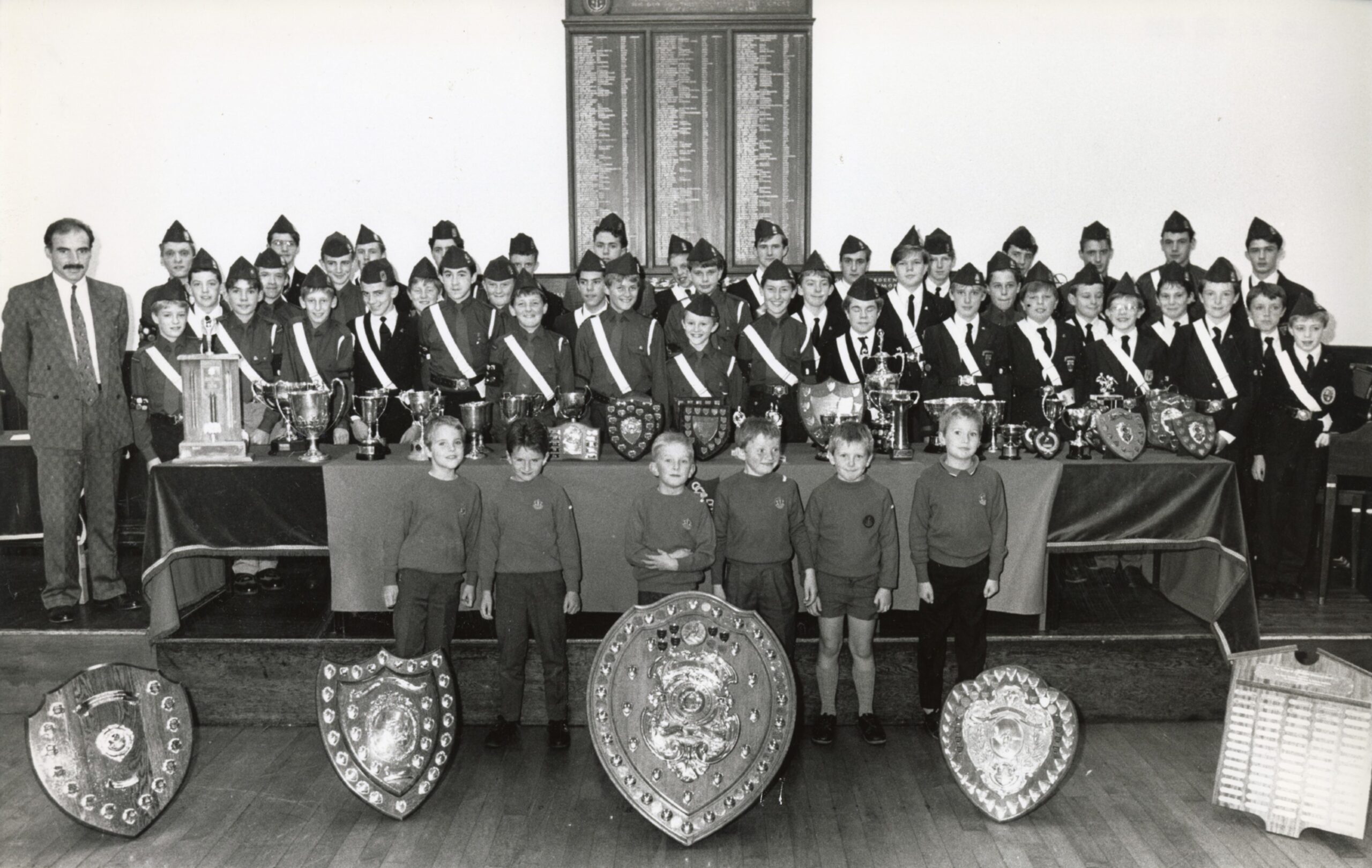 Image shows members of the Aberdeen Boys' Brigade standing beside a table that is filled with awards with former Dons player Willie Miller.