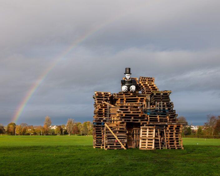 Pile of wood with Guy Fawkes figure on top for Elgin bonfire and fireworks night.