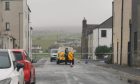 Police car and officer behind police tape on Kirkwall street