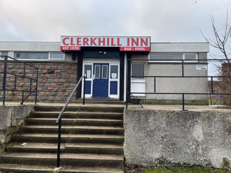 Exterior image of the pub's main door painted in blue with the red lettered Clerkhill Inn sign above