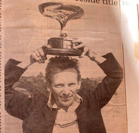 Late Deeside Golf Club player Dick Willox holding a trophy over his head