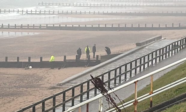 Police investigating down on the sand at Aberdeen beach.