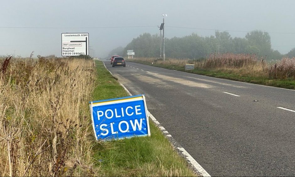 'Police slow' sign on the A941 in Moray, where the crash occurred.