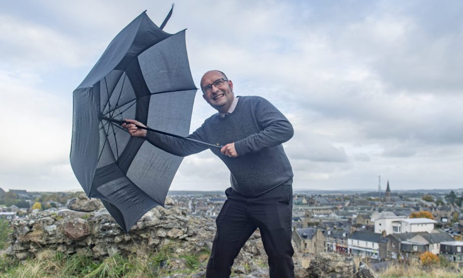 David Mackay holding umbrella on Ladyhill in Elgin. 