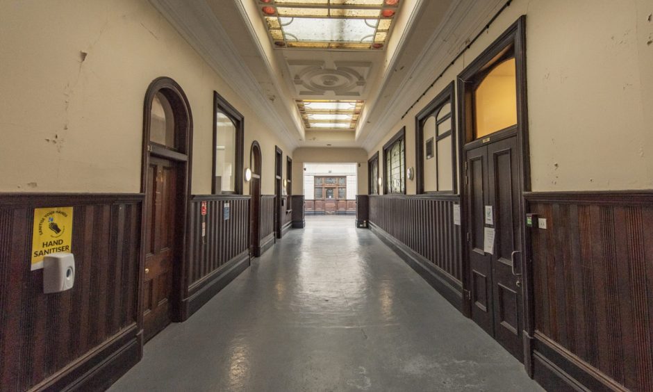 Down long hallway inside ticket hall. 