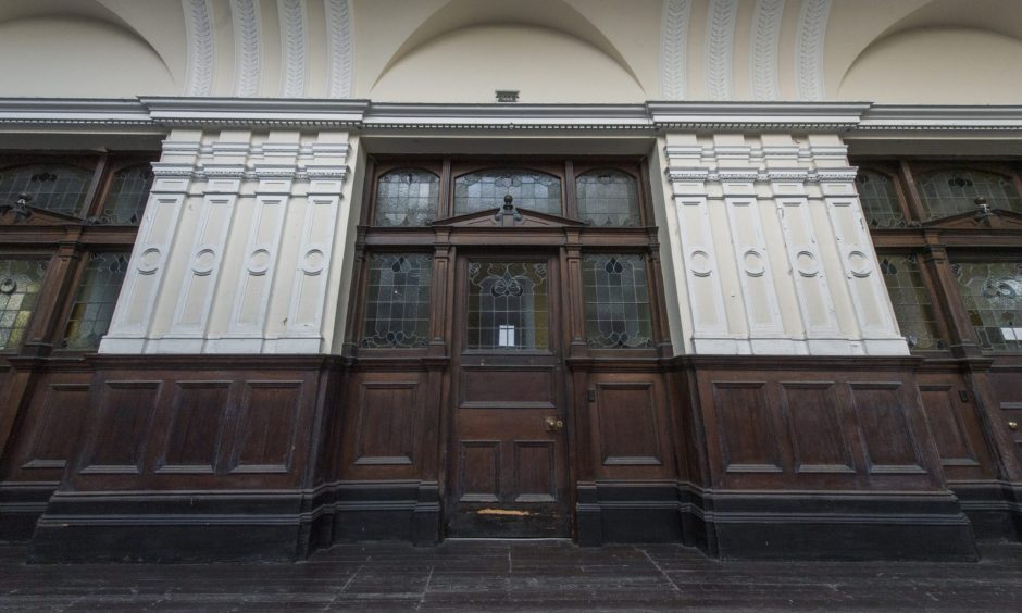 Wooden door and stained glass in old ticket hall. 