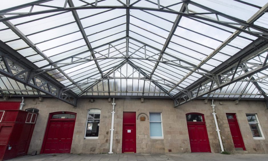 Red doors under old platform roof. 