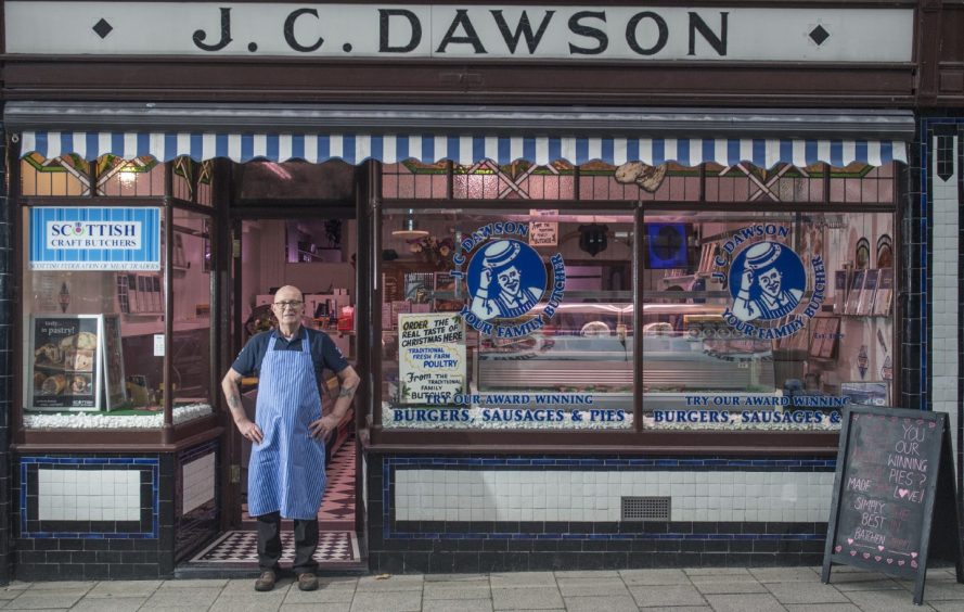 Michael Dawson outside front door of butcher shop. 