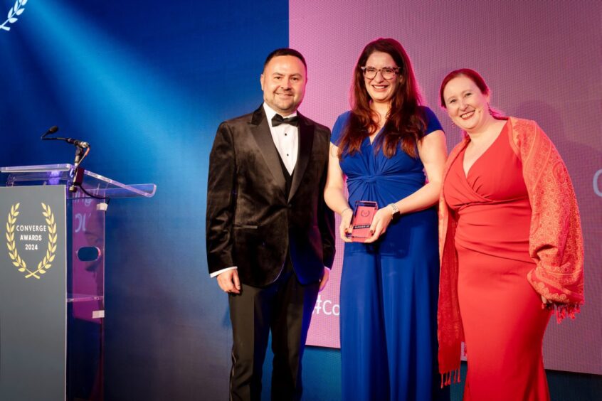 Jillian, holding her award, with Adam Kosterka and Lisa Herron of Converge. 