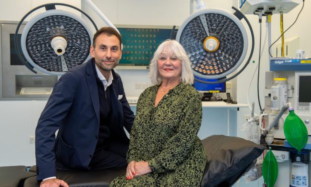 Neurosurgeon Anastasios Giamouriadis and patient Doreen Adams pictured in hospital theatre