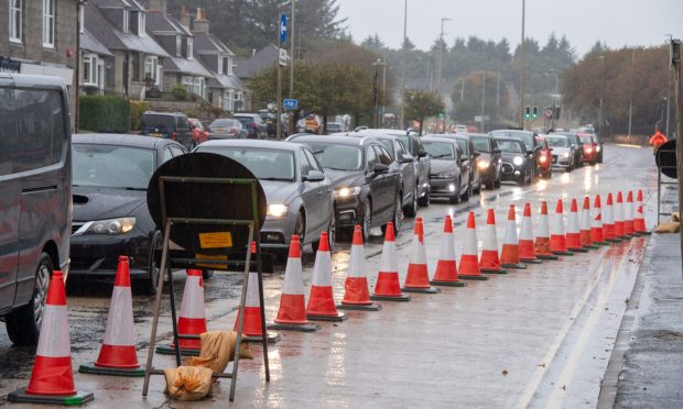 Cars lined up next to lane closure on Ellon Road.