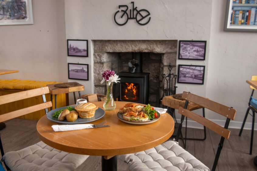 A cosy fire with the food on a table at Spider on a Bicycle in Aboyne