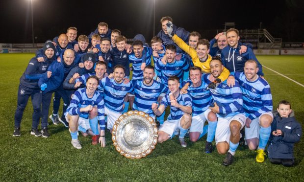 CR0046228 Sophie Goodwin request, Aberdeen.    
Aberdeen B v Banks o' Dee: Morrison Motors Aberdeenshire Shield - Cup Final at Balmoral Stadium, Aberdeen.   
Picture shows; Banks of Dee celebrate with Kane Winton who collected the trophy        
Wednesday 13 December 2023
Image: Kami Thomson/DC Thomson