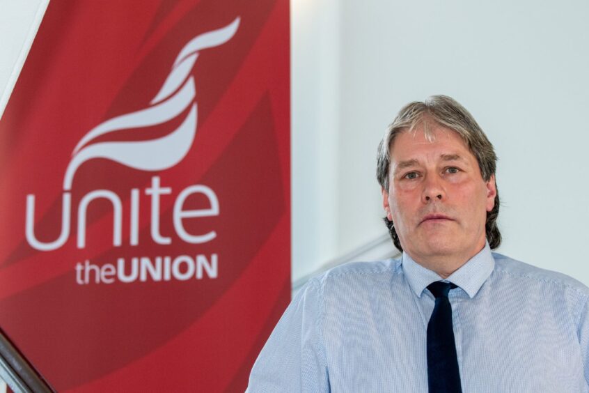 John Boland standing in front of red Unite the Union sign