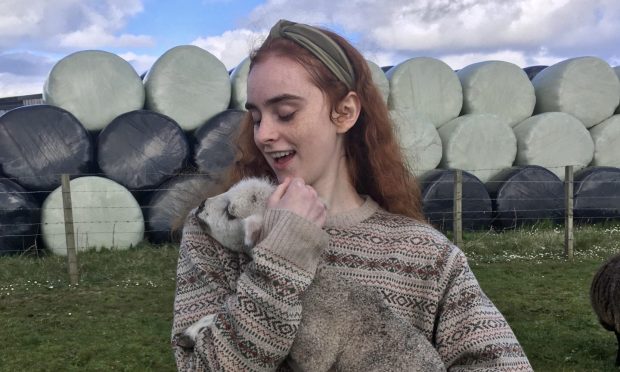 Actor Eilidh Fisher with a lamb in Orkney