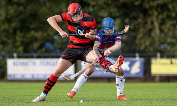 Oban's Andrew Macdonald keeps the ball from James Falconer (Kingussie).  Image: Neil Paterson.