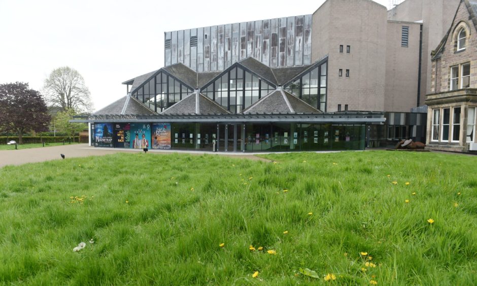 View of Eden Court Theatre from across the green grass.