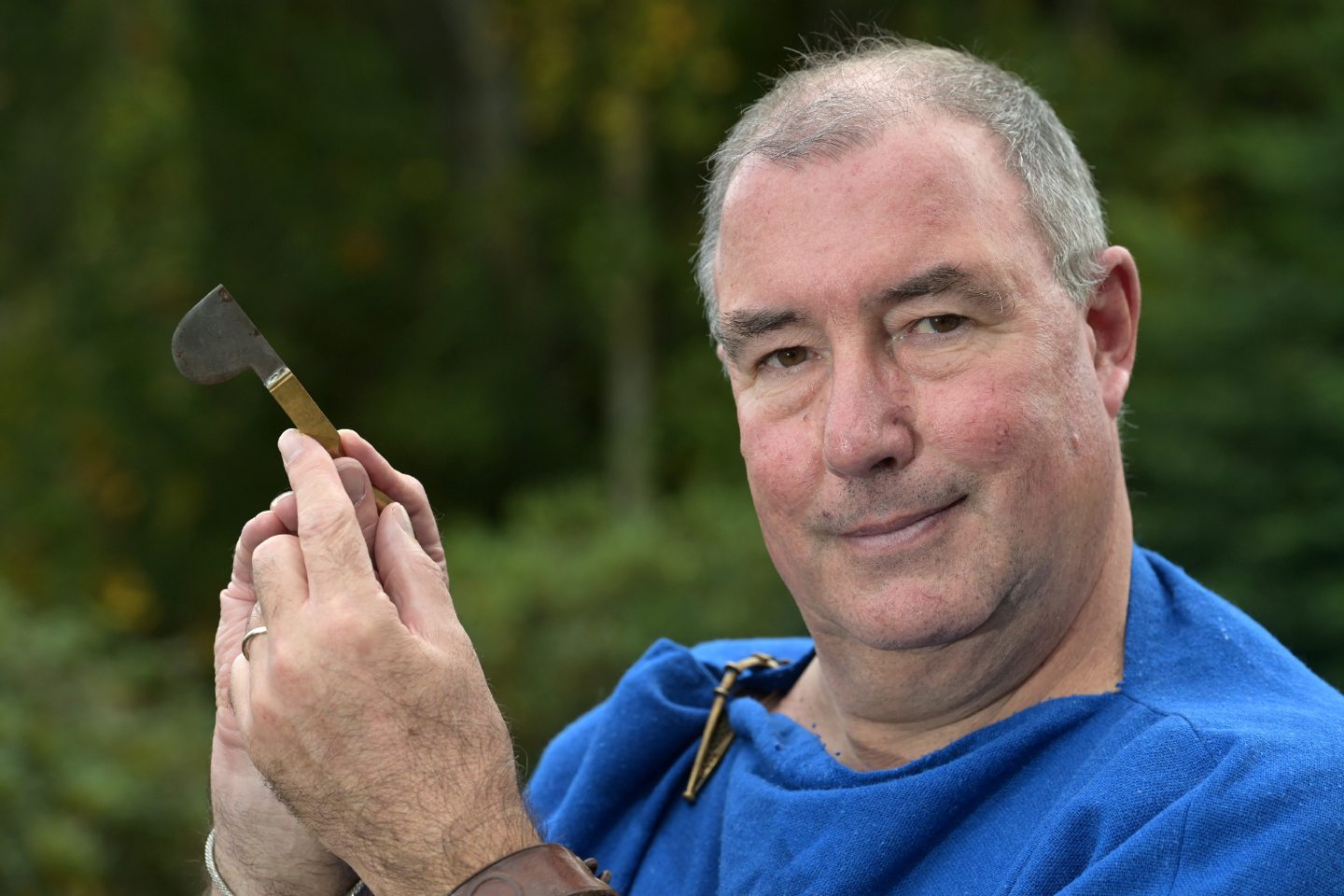 Andrew dressed as Marcus the Medicus holding a replica of a medical scalpel from Roman times.