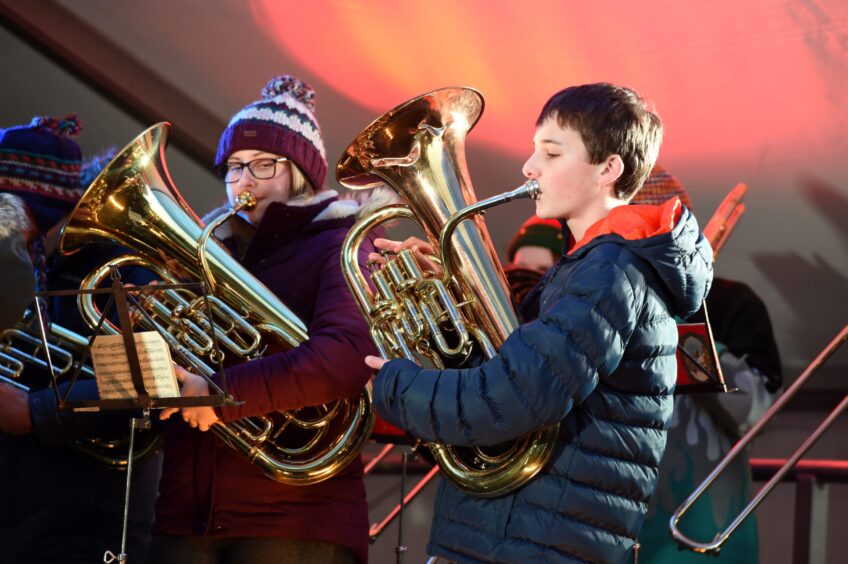 Two people playing trombones