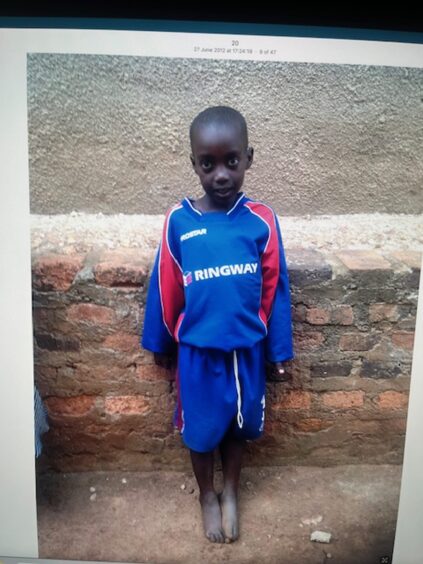 Precious as a tiny girl in a football strip who was sponsored through the charity.