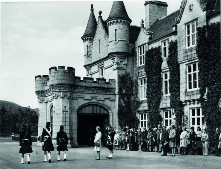 he Queen outside her castle at Balmoral presenting regemental colours to 1st Battalion Gordon Highlanders.