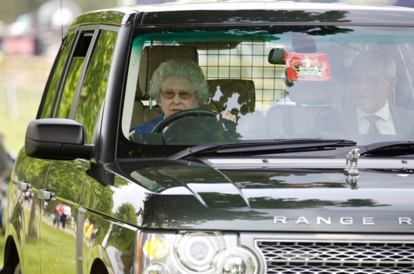 Picture of the late Queen driving her Range Rover on the grounds of Balmoral.