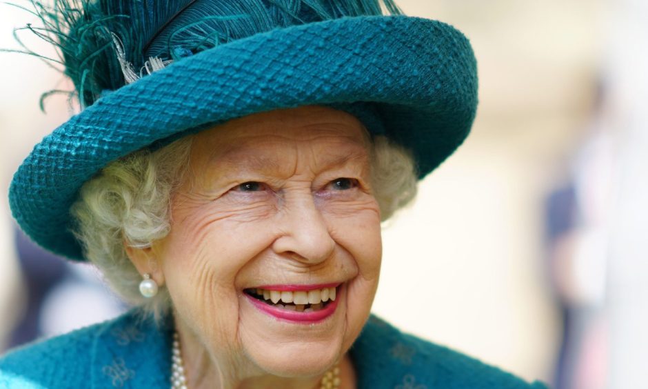 Picture of Queen Elizabeth wearing a teal suit and hat.