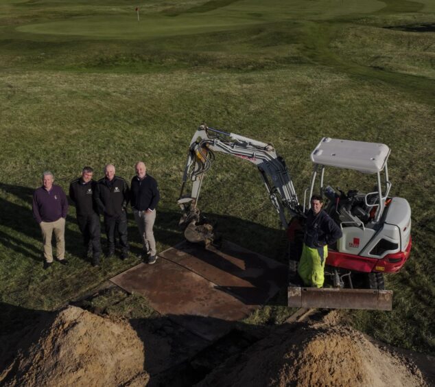 Workers stand beside digger on the right as they break ground on new new £1.5 million high-tech irrigation system.