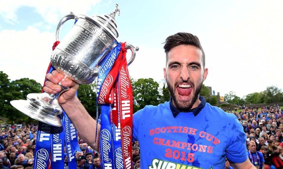 Graeme Shinnie holds up the Scottish Cup before a crowd of Caley Thistle fans