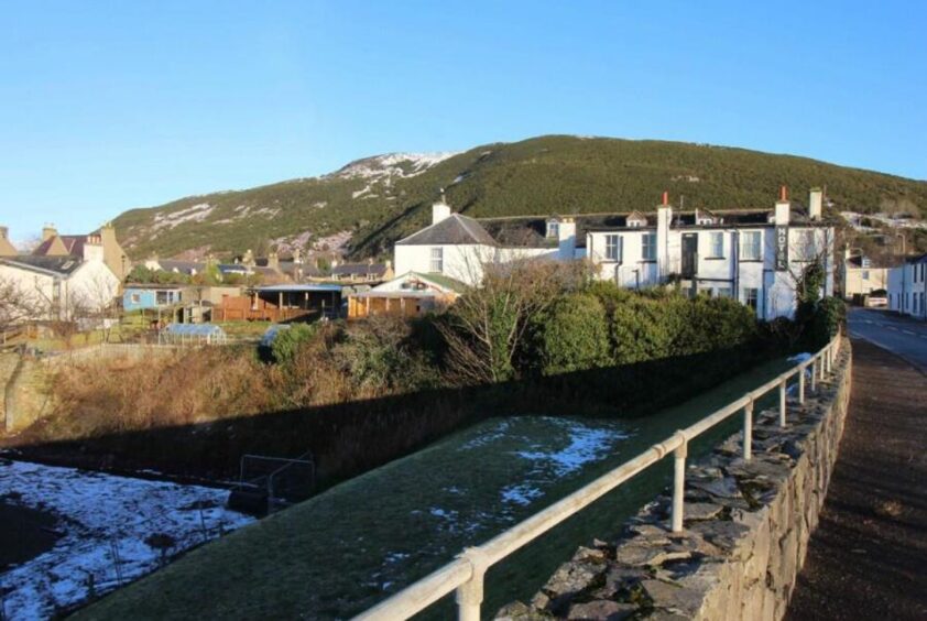 View of rear of Belgrave Arms Hotel with river running behind the hotel. 