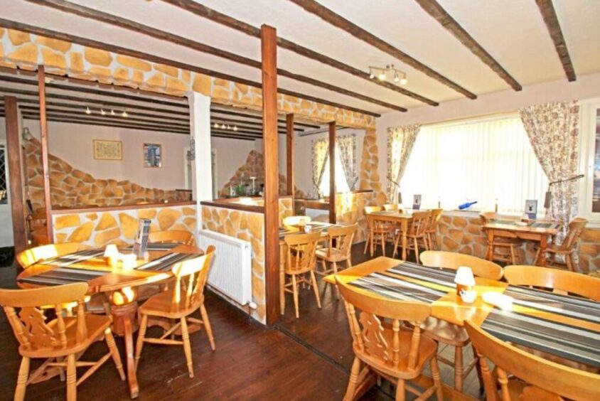 Bright and open dining room with wooden tables and chairs. 